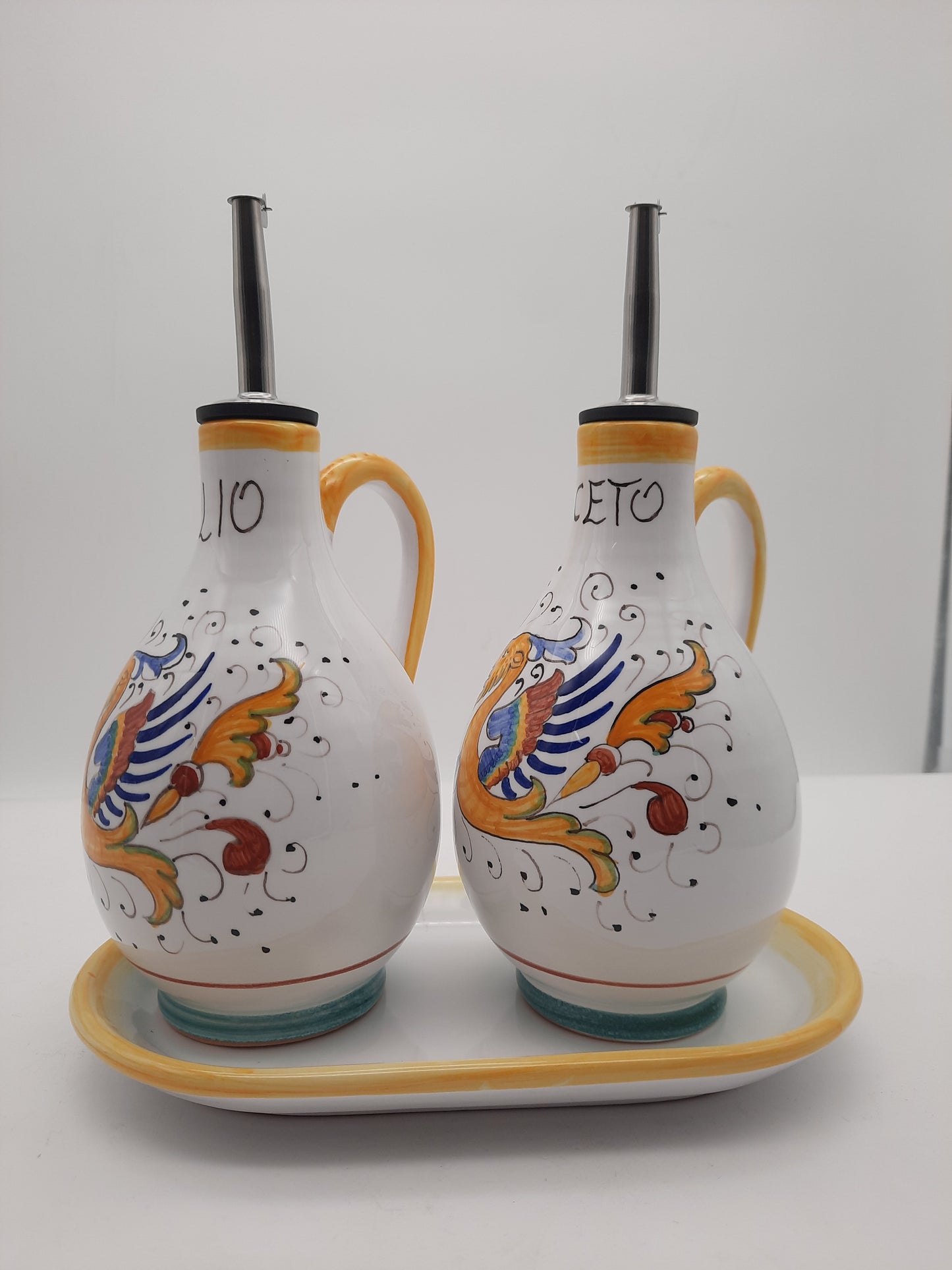 Set olio e aceto cm 15 decoro Raffaellesco con manico e gocciolatoio per una tavola colorata e funzionale.