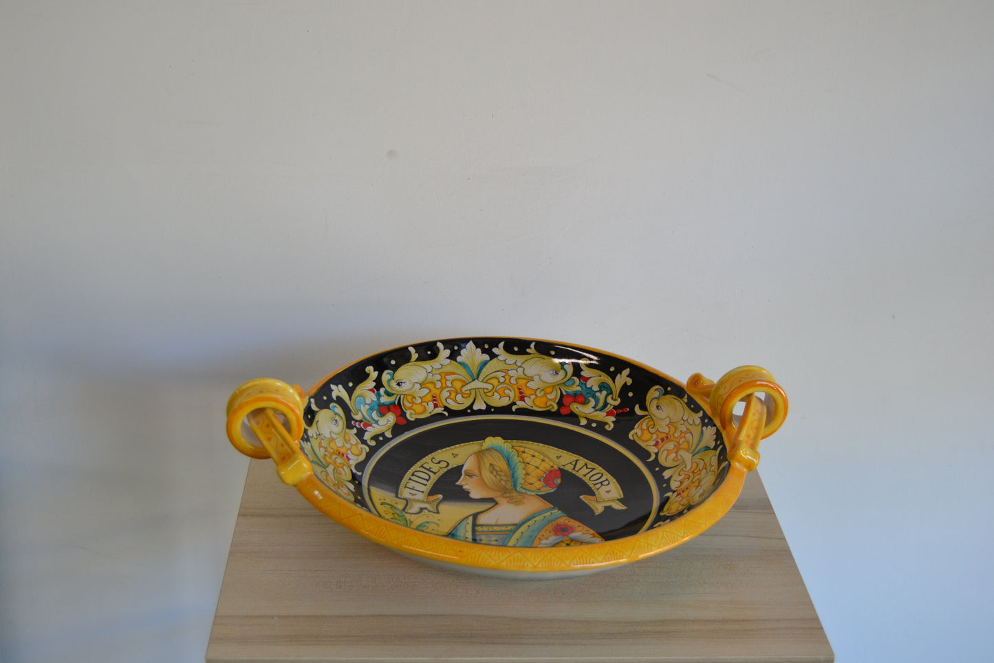 Centrotavola con manici dipinto a mano in ceramica tornito a mano cm 42. Un pezzo classico della tradizione derutese. Al centro figura femminile Rinascimentale e con bordo Delfini