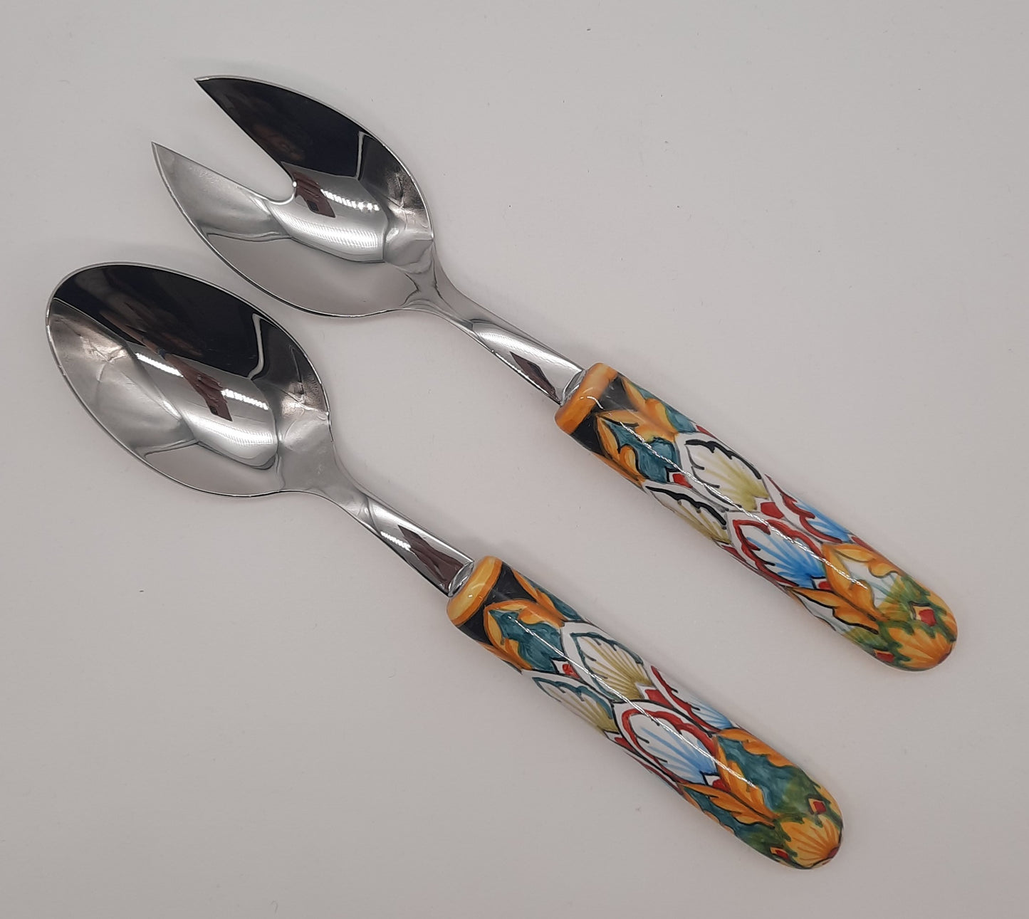 Coppia posate insalata Decoro Vario Geometrico. Manico in ceramica dipinto a mano, entrambi i cucchiai sono in acciaio inox.